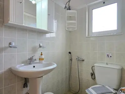 a bathroom with a sink and a toilet and a window at Inna Rooms in Fournádhos