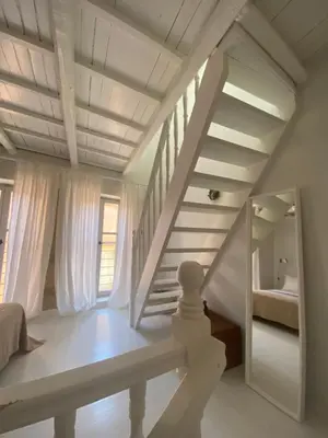 a white room with a staircase and a bedroom at Reas House in Chania Town