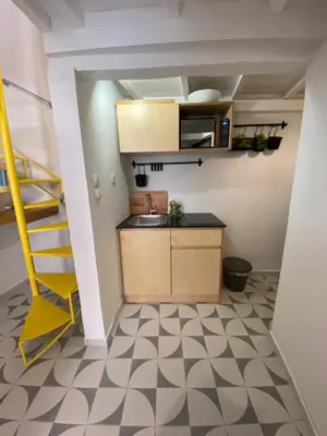 a small kitchen with a sink and a staircase at Reas House in Chania Town