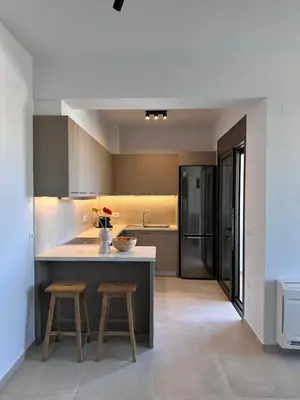 a kitchen with a counter and two stools in it at Etherio Urban Loft in Chania Town