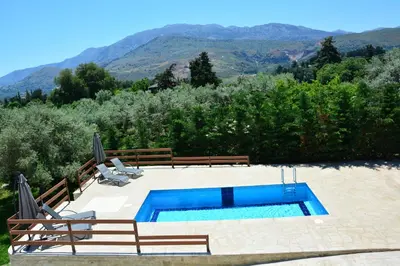 a swimming pool with two lounge chairs at Villa Ikaros in Kalamitsi Amygdali