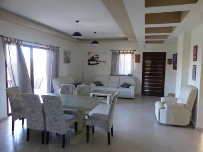 a living room with a table and chairs at Villa Ikaros in Kalamitsi Amygdali
