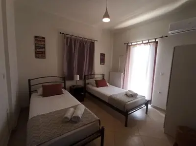a bedroom with two beds and a window at Villa Ikaros in Kalamitsi Amygdali