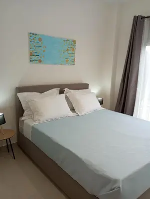 a bedroom with a large bed with white pillows at Golden Orb in Chania Town