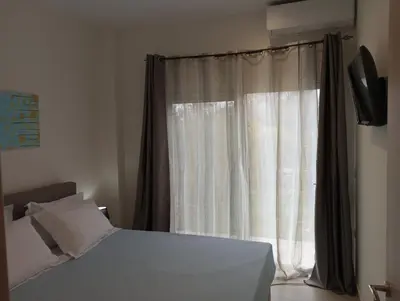 a bedroom with a bed and a window at Golden Orb in Chania Town