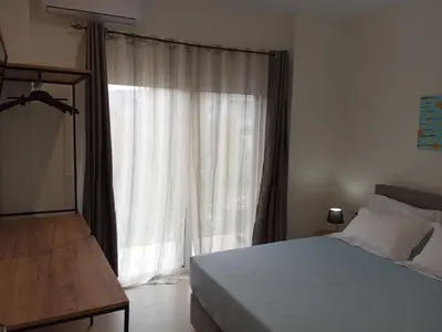 a bedroom with a bed and a large window at Silver Orb in Chania Town