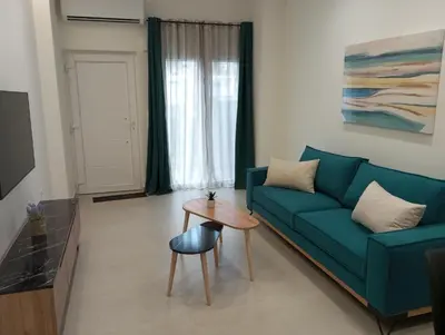 a living room with a blue couch and a table at Silver Orb in Chania Town