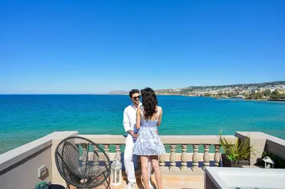 a man and a woman standing next to the ocean at Kumka seafront suite in Chania Town