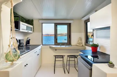 a kitchen with two stools in front of two windows at Kumka seafront suite in Chania Town