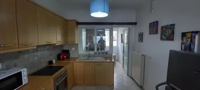 a kitchen with wooden cabinets and a sink and a window at Seaside apartment in Chania in Chania Town