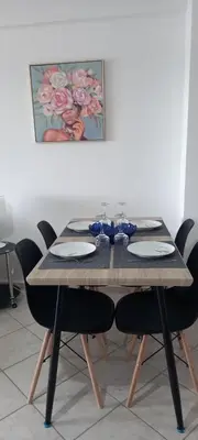 a dining room table with black chairs and a painting at Seaside apartment in Chania in Chania Town