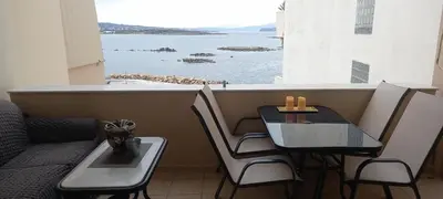 a table and chairs with a view of the ocean at Seaside apartment in Chania in Chania Town