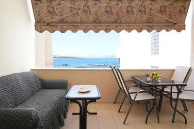 a living room with a couch and a table and a window at Seaside apartment in Chania in Chania Town