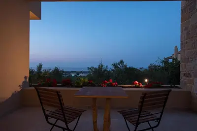 a table and two chairs on a balcony with a view at Villa Ianira in Kolymvari