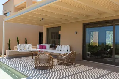 a patio with wicker chairs and a couch on a patio at Villa Ianira in Kolymvari