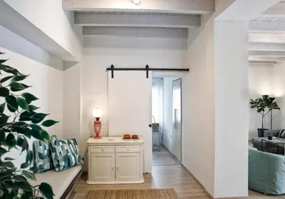 a hallway with white walls and a table with a plant at Serena Residence in Chania Town
