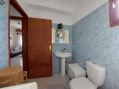 a bathroom with a white toilet and a sink at Stavros Oak Tree House in Vasilópoulon