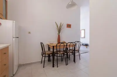 a dining room with a table and chairs and a refrigerator at Stavros Oak Tree House in Vasilópoulon