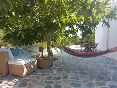 a hammock under a tree on a patio at Stavros Oak Tree House in Vasilópoulon