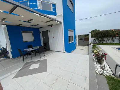a patio with a blue building and a table and chairs at Villa Anastasia Sissy in Módhion