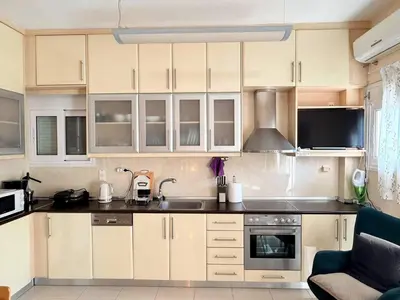 a kitchen with white cabinets and a sink at Little Central Apartment-1min walk from everywhere in Chania Town