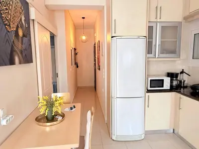 a small kitchen with a refrigerator and a table at Little Central Apartment-1min walk from everywhere in Chania Town