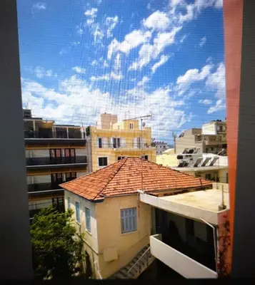 a view from a window of a building with a roof at Little Central Apartment-1min walk from everywhere in Chania Town