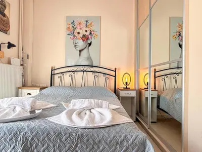 a bedroom with a bed and a painting of a woman at Little Central Apartment-1min walk from everywhere in Chania Town