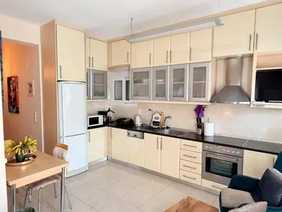 a kitchen with white cabinets and a white refrigerator at Little Central Apartment-1min walk from everywhere in Chania Town