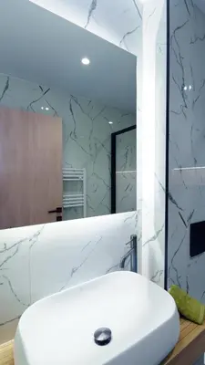 a bathroom with a white sink and a mirror at Seascape Luxury Apartment 2 in Kounoupidhianá