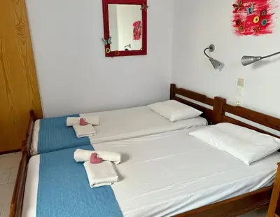 two twin beds in a room with a mirror at BONATSA Rooms 2 in Palaiochóra