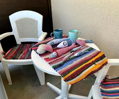 a white table with a blanket and two cups and a chair at BONATSA Rooms 2 in Palaiochóra