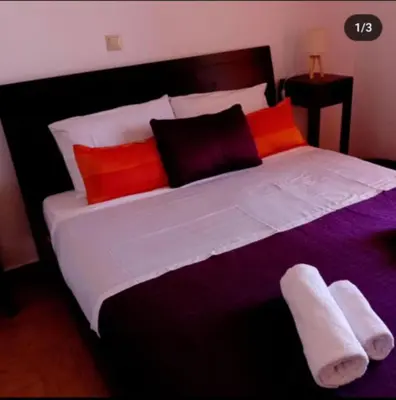 a large bed with red and orange pillows at Villa Archontoula in Kambánion