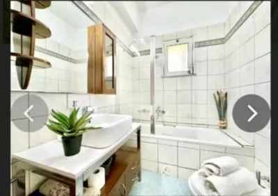 a bathroom with a sink and a tub with a potted plant at Villa Archontoula in Kambánion