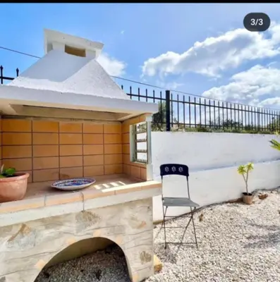 a patio with a table and a chair at Villa Archontoula in Kambánion