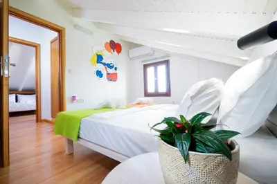 a bedroom with a large white bed with a plant at Loft Apartment in Chania Town