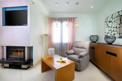 a living room with a couch chair and a television at Loft Apartment in Chania Town