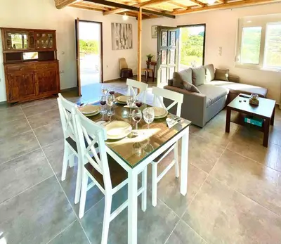 a living room with a table and chairs and a couch at Villa Voleonas-private pool & olive grove Chania in Kounoupidhianá