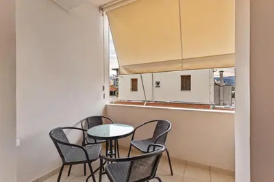 a small table and chairs in a room with a window at Marika's Apartment in Chania in Chania Town