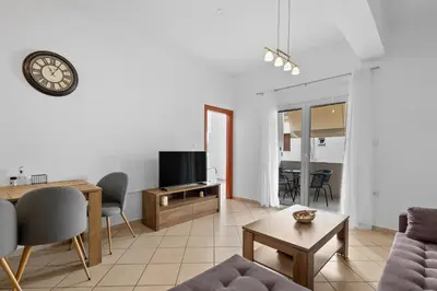 a living room with a couch and a tv and a table at Marika's Apartment in Chania in Chania Town