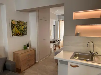 a kitchen with a sink and a living room at Elias Nest in Galatás
