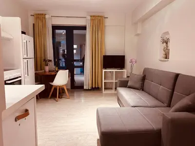 a living room with a couch and a kitchen at Elias Nest in Galatás