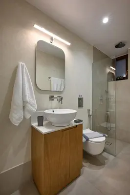 a bathroom with a sink and a toilet and a mirror at Evans Villas in Kissamos