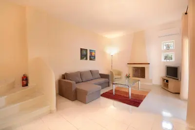 a living room with a couch and a tv at Villa Silvia by Andrian Villas in Kalamítsion Alexándrou