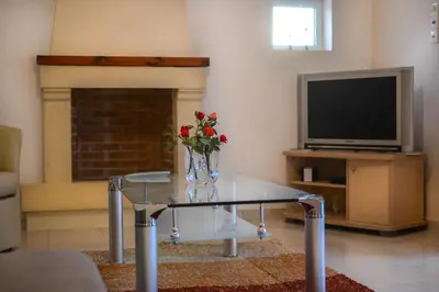 a living room with a glass coffee table and a tv at Villa Silvia by Andrian Villas in Kalamítsion Alexándrou
