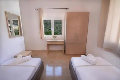 a room with two beds and a sink in it at Villa Silvia by Andrian Villas in Kalamítsion Alexándrou