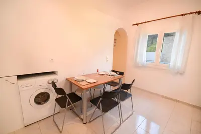 a kitchen with a table and chairs and a washing machine at Villa Silvia by Andrian Villas in Kalamítsion Alexándrou