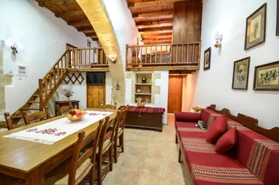 a dining room with a table and chairs and a staircase at Villa Rouga by Andrian Villas in Kalamítsion Alexándrou