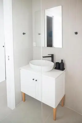 a white bathroom with a sink and a mirror at Elia Suites in Falasarna