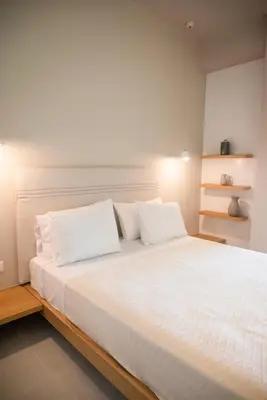 a bedroom with a large white bed with white pillows at Elia Suites in Falasarna